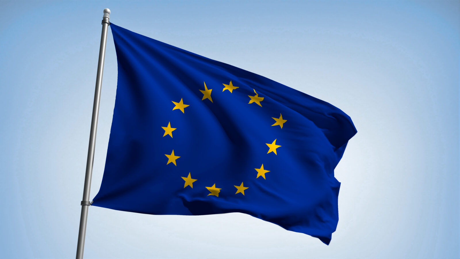 Vlag van Europa die wappert in de wind tegen een blauwe lucht als achtergrond